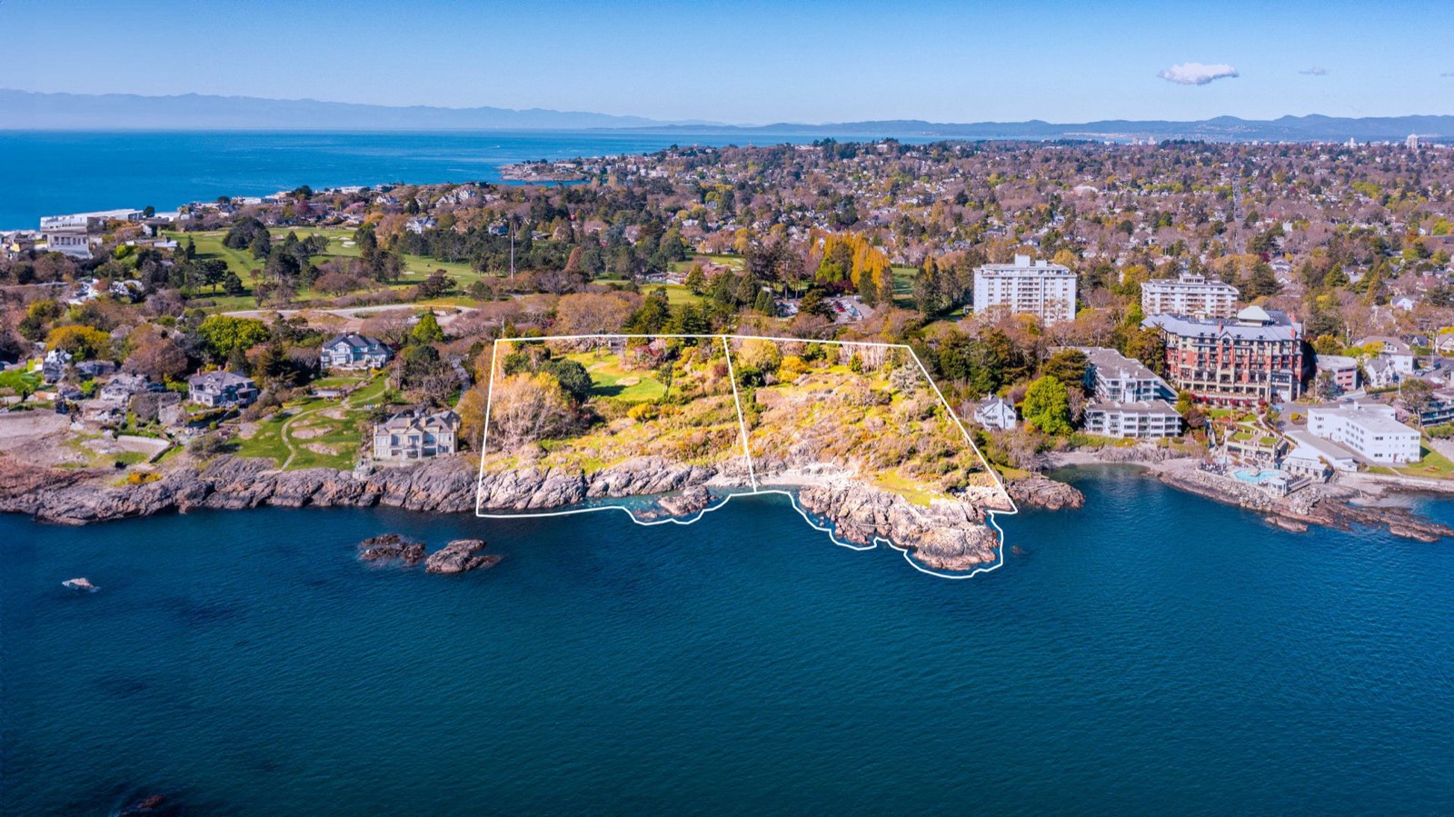 Aerial photograph of 1069 and 1101 Beach Drive with both property boundaries outlined in white on a rocky headland facing Haro Strait